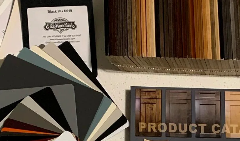 Door samples, laminate colour chips and wood veneers spread out on a counter