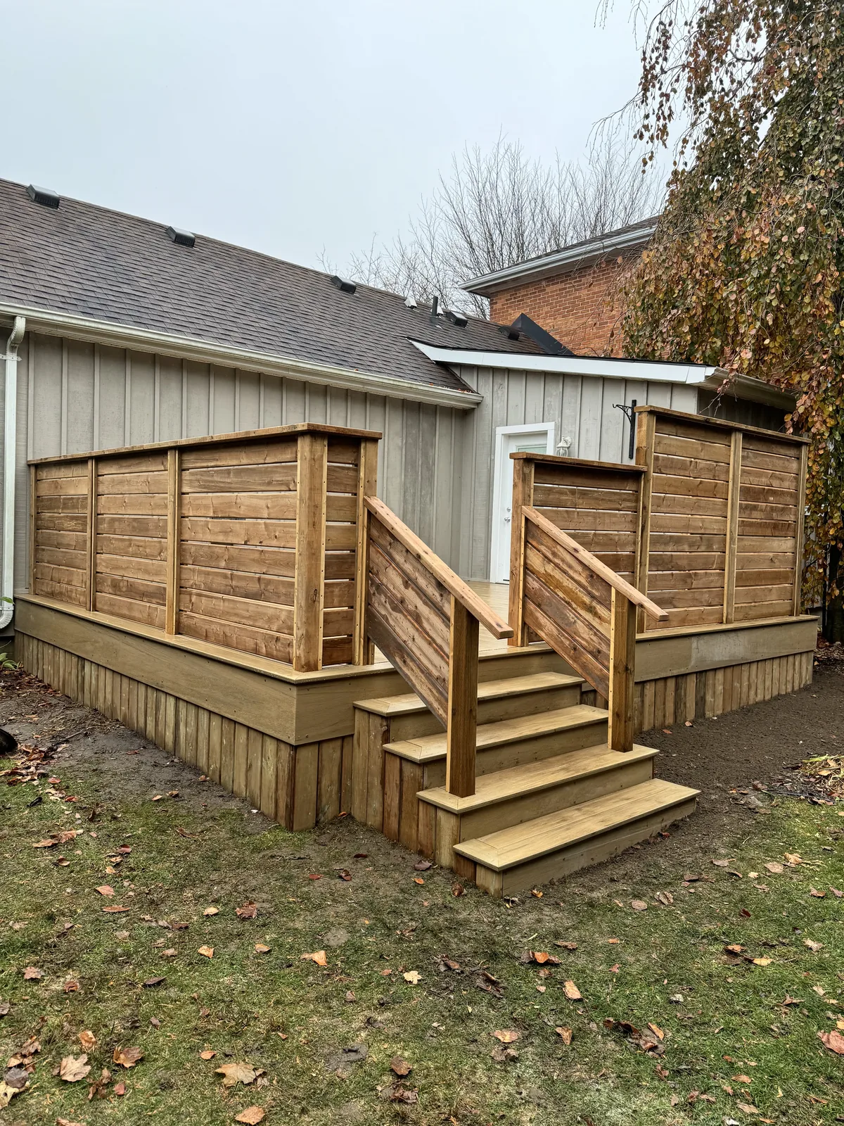 Raised deck with cedar privacy screens and steps down to the garden