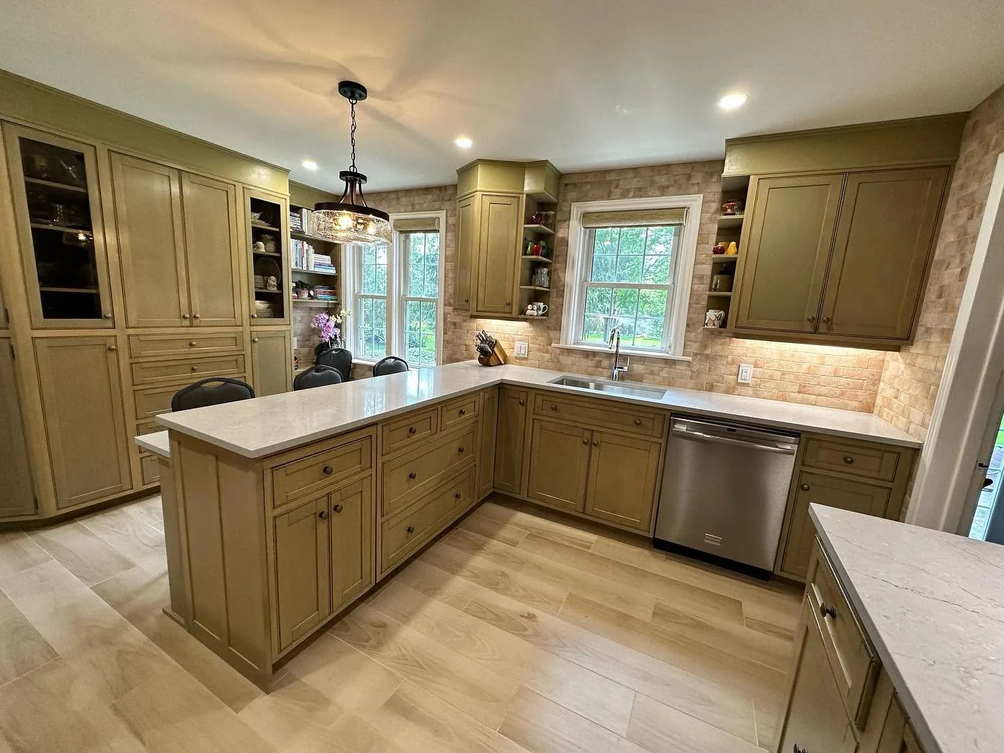 The finished kitchen from the doorway, quartz peninsula and kept cabinetry