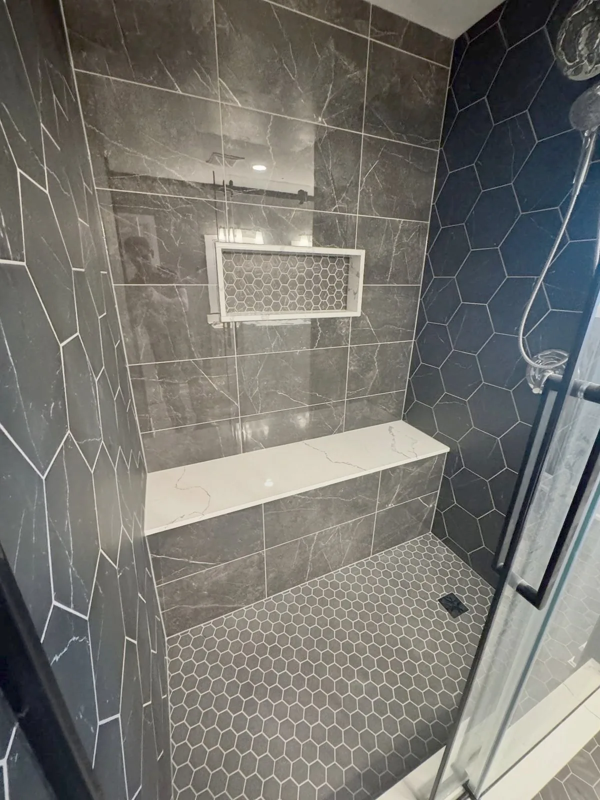 Charcoal shower with hexagon feature wall and quartz bench