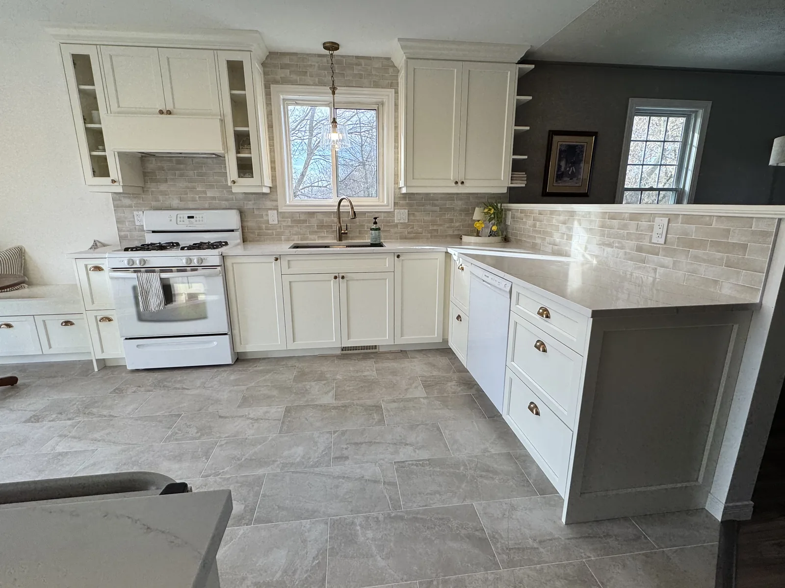 White kitchen with glazed upper cabinets and a tiled floor