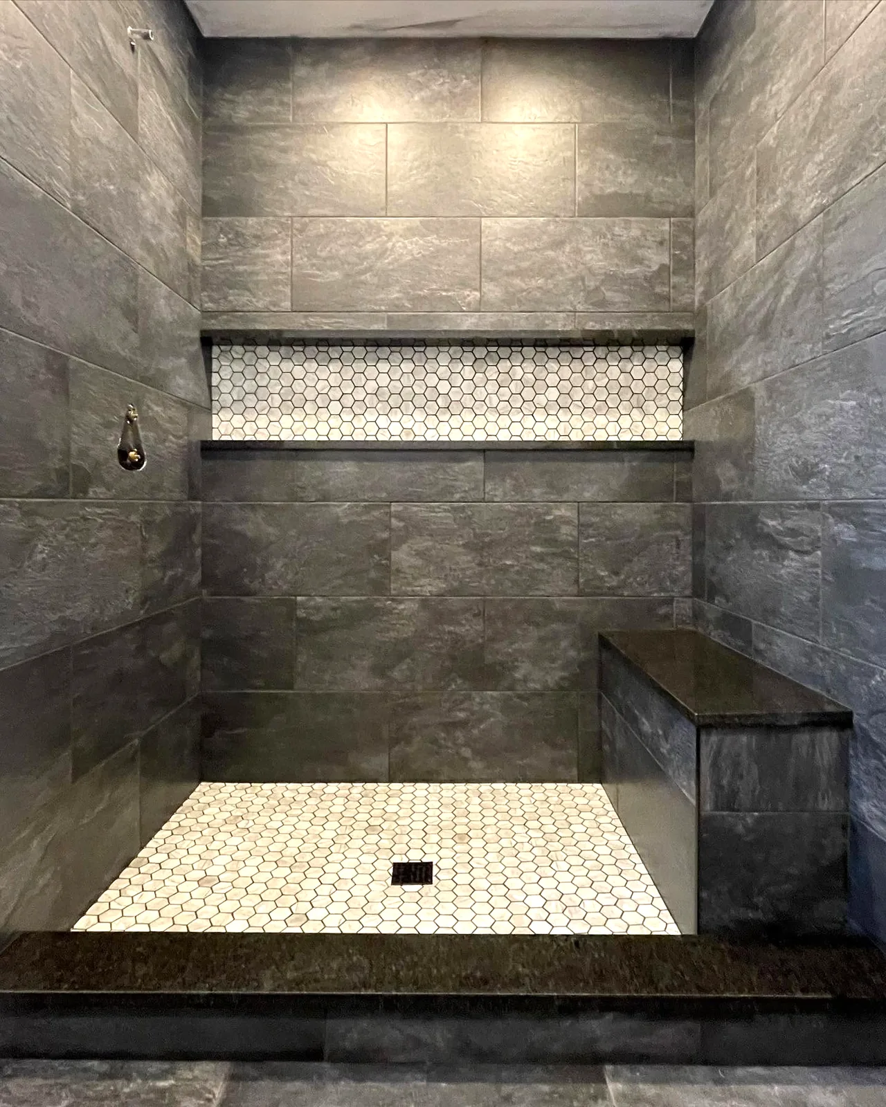 The finished shower, hex mosaic band across the niche and the same mosaic underfoot
