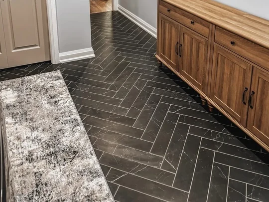 Finished basement hallway with herringbone tile running through