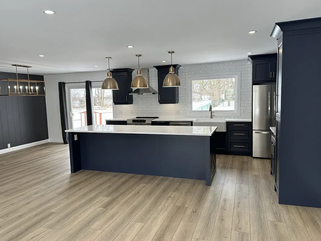 Finished navy kitchen with island and brass pendants