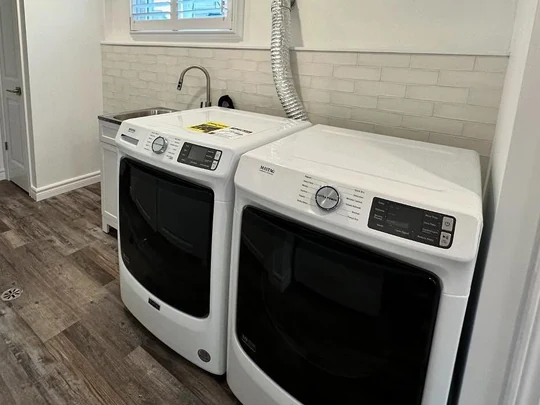 Basement laundry with a tiled backsplash and coffered ceiling