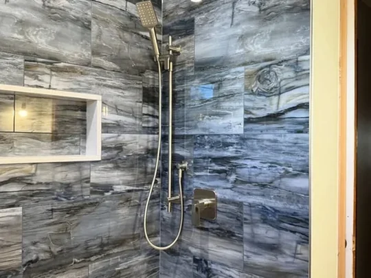 Large-format porcelain run floor to ceiling in a shower