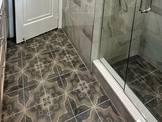 Patterned floor tile running through to a tiled shower