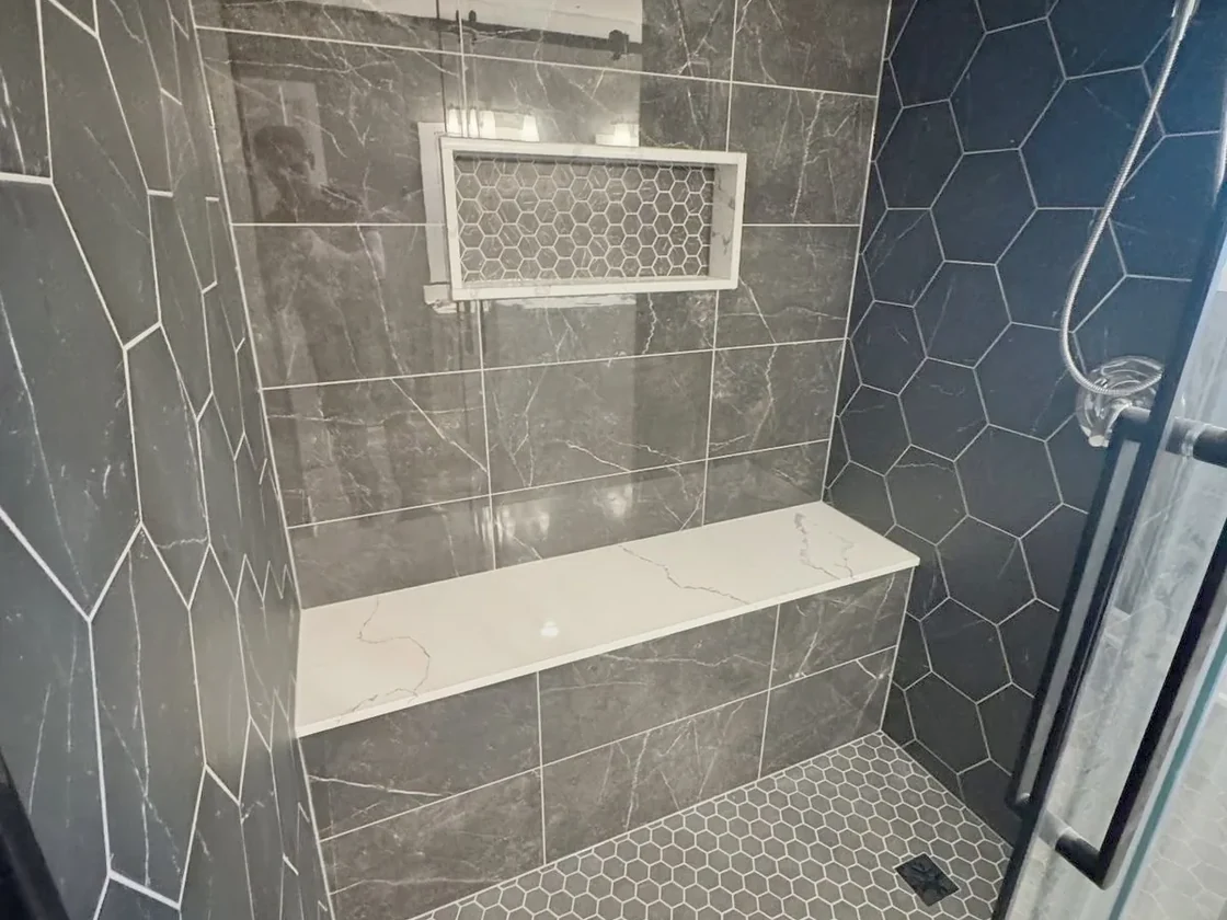 Charcoal shower with a hexagon feature wall and a quartz bench
